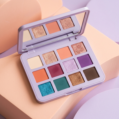 Main image 1: open lavender 12-color eyeshadow palette on a peach and lilac set